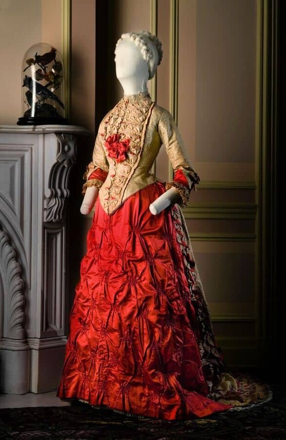 Many fashion critics recommended bright colors that would feel less garish in artificial lighting. Scarlet and gold silk satin and brocade gown, ca. 1883. Worn by Annie Otis Sanders (1855-1933). Gift of Harold T. Clark 46.812