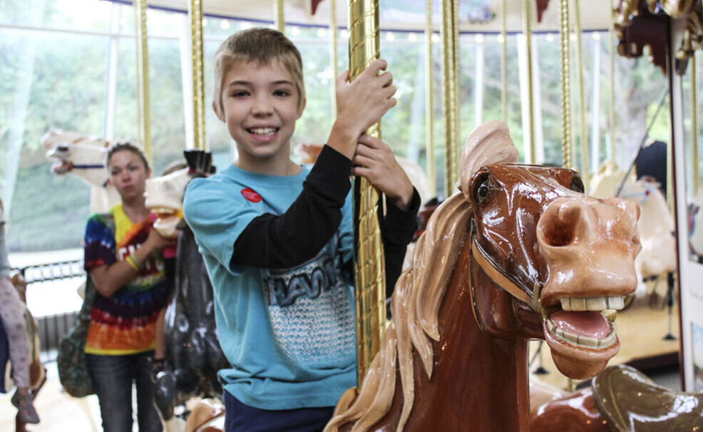 Boy riding Euclid Beach Park Grand Carousel